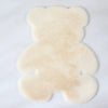 A fluffy, light beige bear-shaped non-slip area rug.