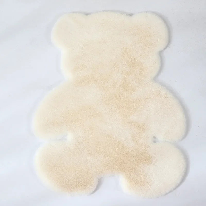 A fluffy, light beige bear-shaped non-slip area rug.