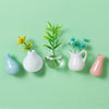 A collection of mini ceramic landscape fridge magnets featuring yellow and blue flowers in various white and pink glass vesse