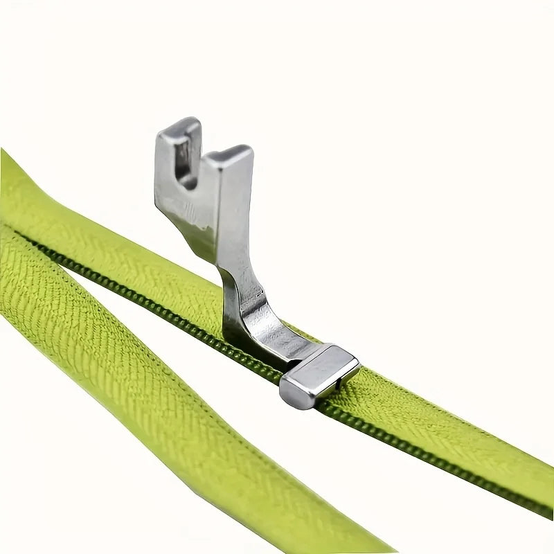 Silver industrial steel presser foot with an invisible zipper attached to a lime green fabric strap.