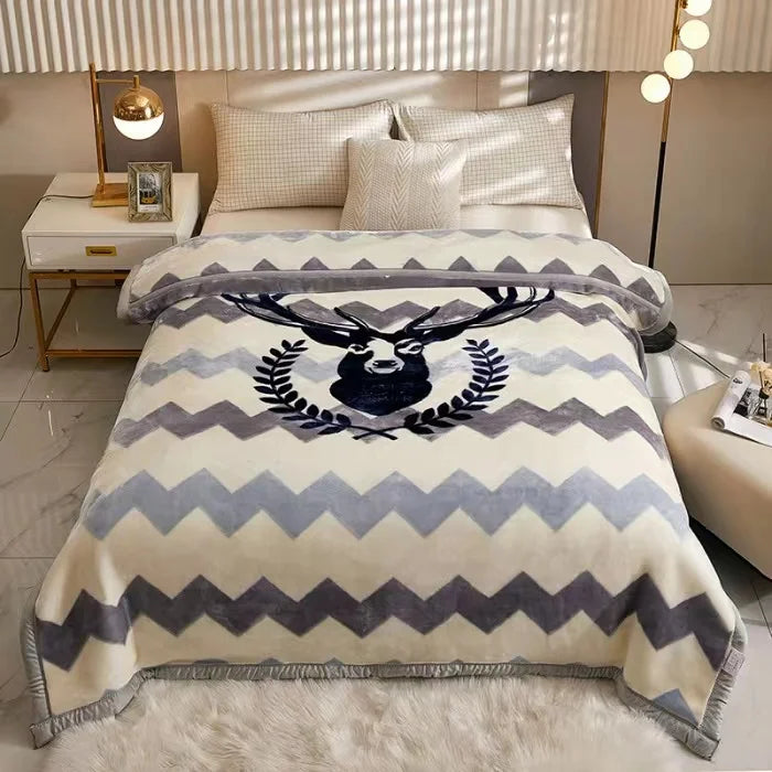A plush mink fleece king size blanket with a gray and cream chevron pattern is displayed on a bed.
