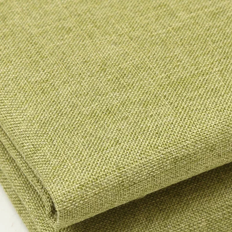 A close-up of coarse olive green linen and cotton fabric rolled up.