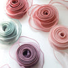 A collection of rolled pink and mauve organza ribbons for crafting