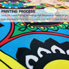 Close-up of a colorful fabric print featuring a black and white motif on a bright blue background.