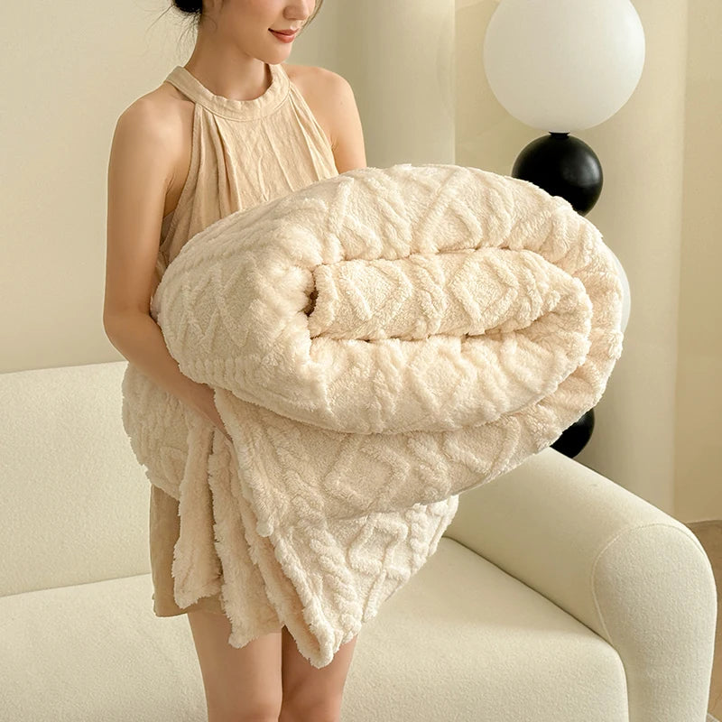 A woman is holding a fluffy, cream-colored coral fleece blanket.