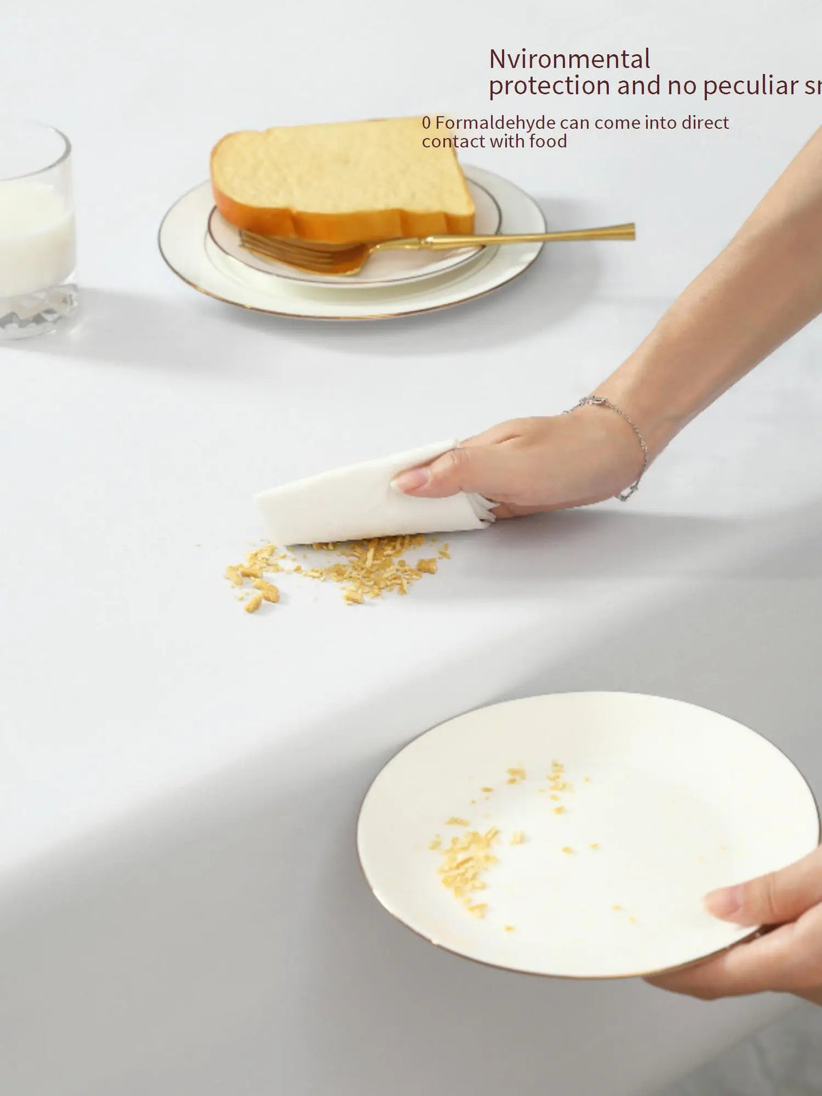 A hand is using a white cloth to wipe food residue from a plate on a table, demonstrating environmental protection.