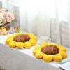 A collection of yellow sunflower shaped throw pillows displayed on a white surface.