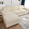 A light beige waterproof jacquard stretch sofa cover draped over a modern sectional sofa in a bright living room.