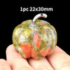 A natural stone pumpkin figurine measuring 22x30mm is held in a hand.