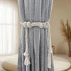 Gray linen curtain with a natural rope tie gathered at the top