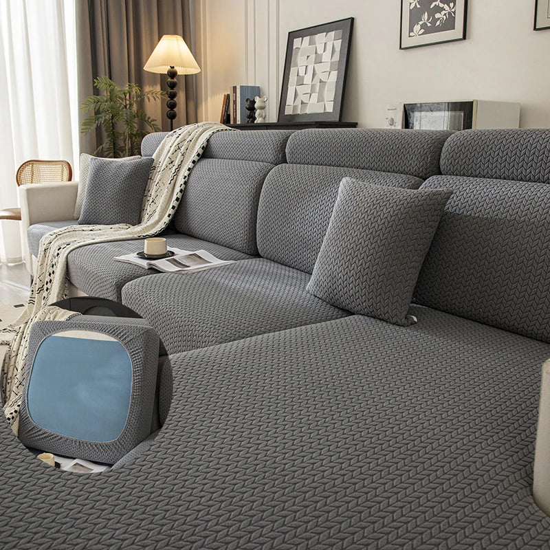 A gray plush elastic sofa cushion cover is displayed on a sofa with decorative pillows and a throw blanket.