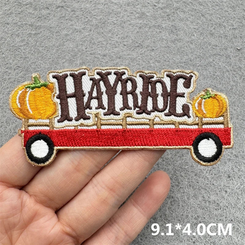 Embroidered patch featuring the word HAYRIDE in a vintage vehicle design with pumpkins