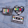 Three embroidered patches featuring a television, a heart, and a cassette tape design on a denim jacket.