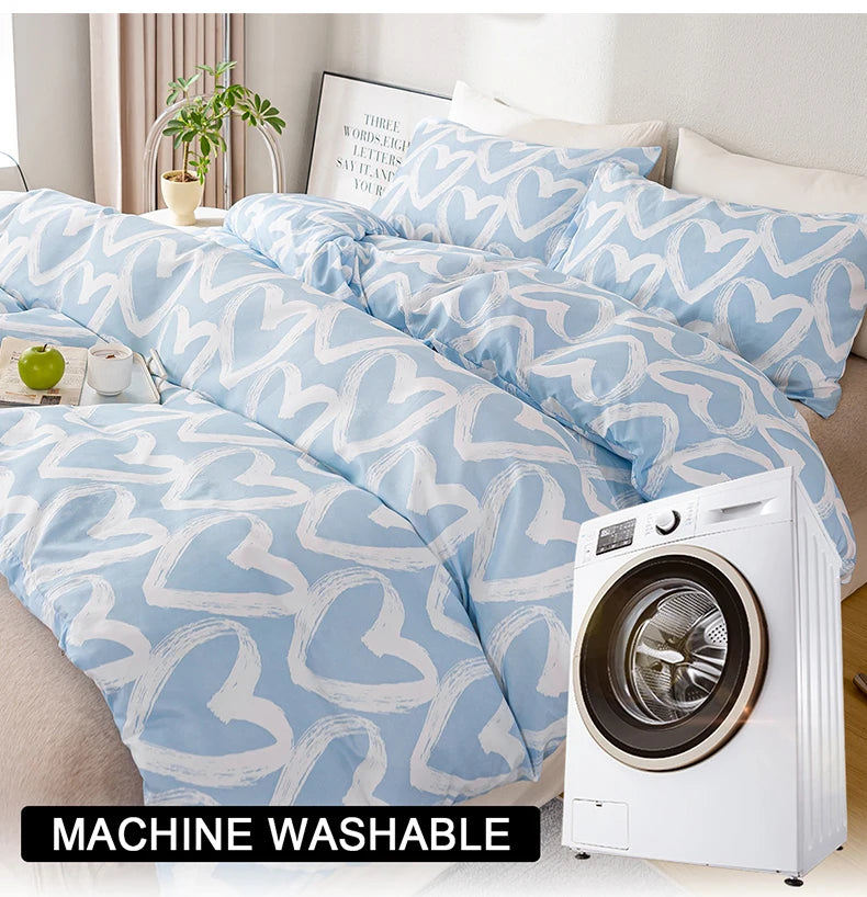 A light blue duvet cover with a white heart print displayed next to a white washing machine.