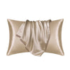 A luxurious satin silk pillow cover in a champagne beige color, draped and folded.