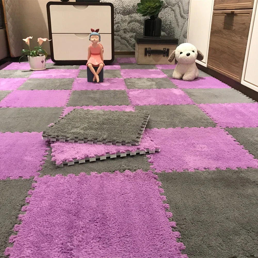 A purple and gray checkered play mat with a pink doll, a white dog plush, and a dark potted plant on a floor.