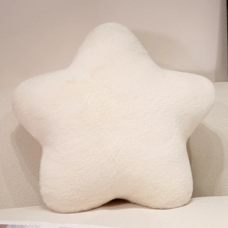 A fluffy white star-shaped decorative throw pillow.
