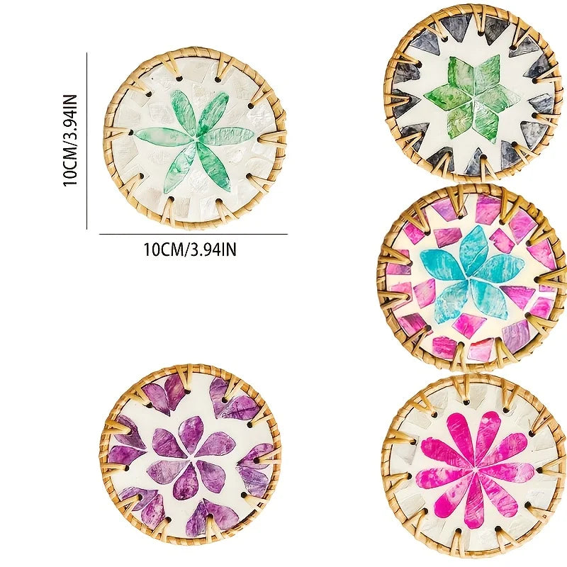 Set of five woven shell coasters featuring floral designs in various shades of green, blue, and purple on natural material