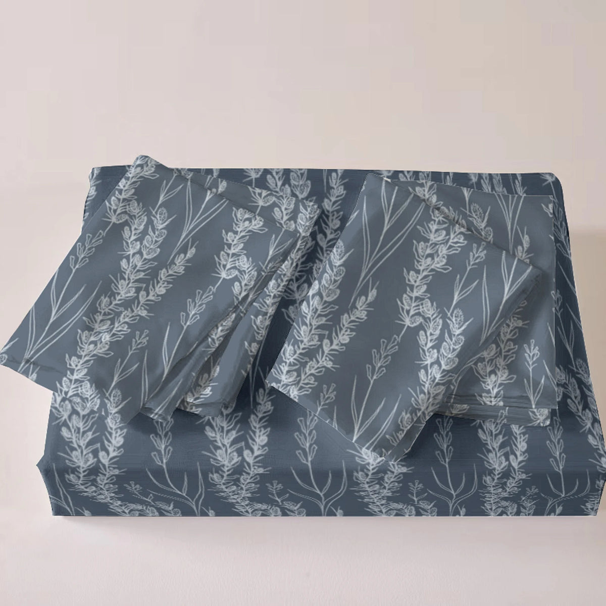 A set of three grey botanical print duvet covers and pillowcases folded on a white surface.