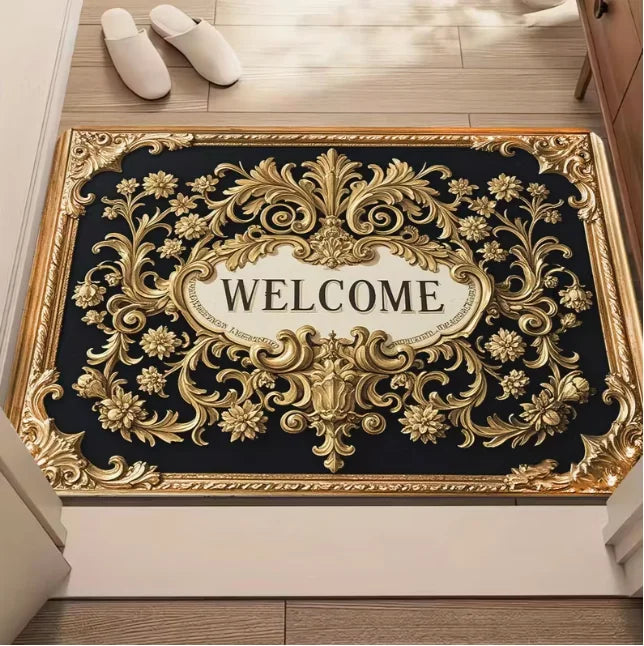 A rectangular entrance door mat with ornate gold detailing and the word WELCOME on a black background