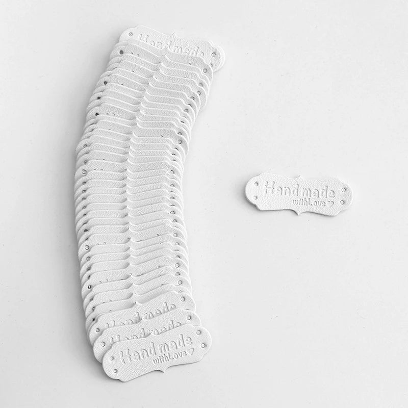 A stack of 50 PU leather embossed tags for handmade crafting in white.