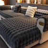 A dark gray plush velvet sofa cover with tufted texture and a light cream cushion displayed indoors.