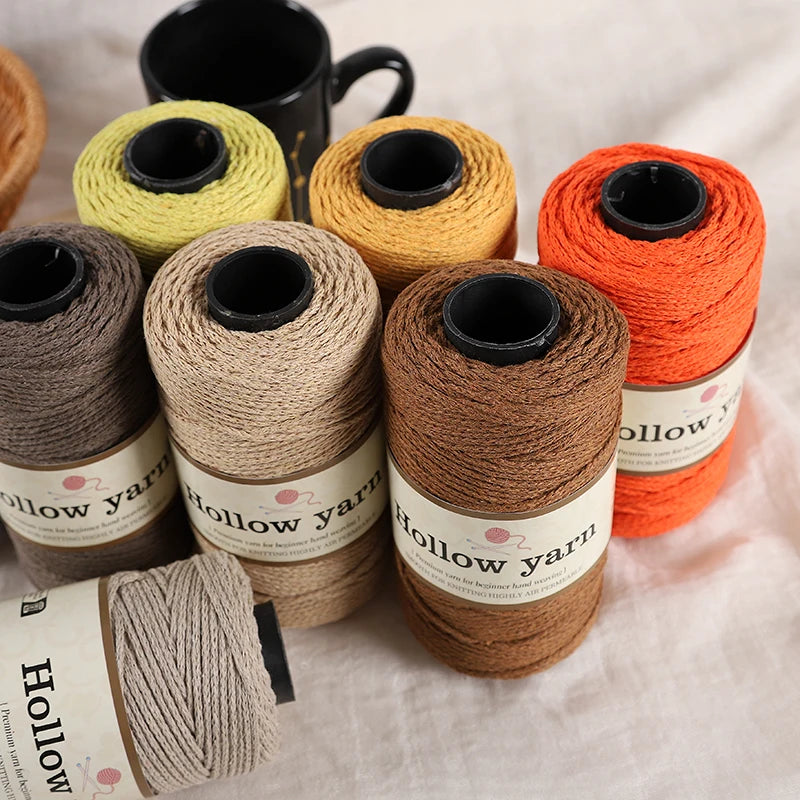 A collection of five spools of Hollow yarn in various shades of yellow and orange for knitting and crochet projects.