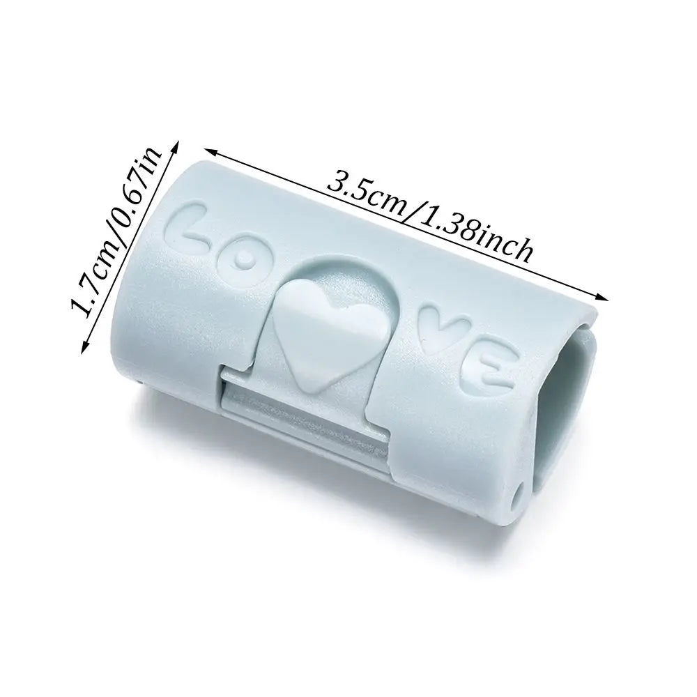 A close-up view of a light blue invisible sheet clip with a heart design, showing its size and shape.