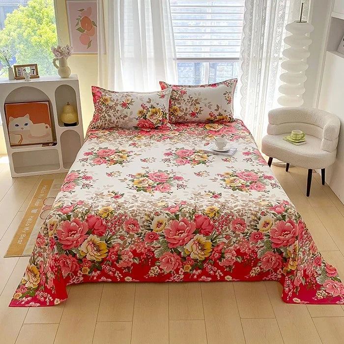 Red floral print flat bed sheets for double beds displayed on a bed in a bright room.