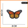 A set of five embroidered butterfly and rose iron-on patches, featuring orange and black designs.