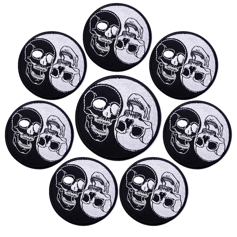 A collection of black and white embroidered skull patches featuring a stylized face design.