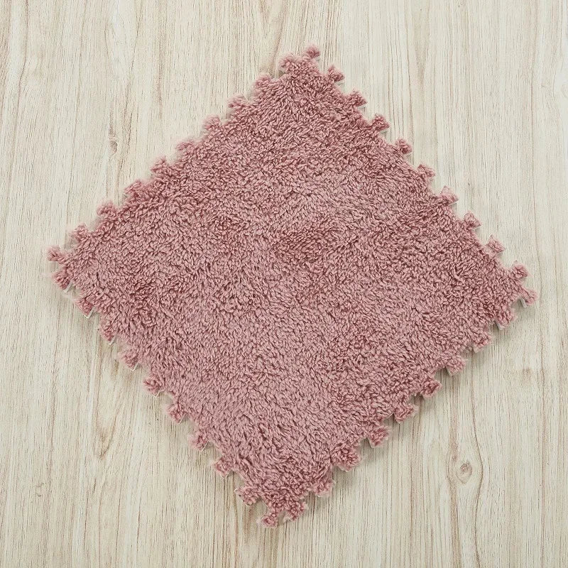 A square, pinkish-brown plush interlocking puzzle rug mat placed on a light wooden surface.