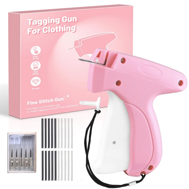 Pink tagging gun for clothing with a white grip and attached needle, shown next to its packaging.