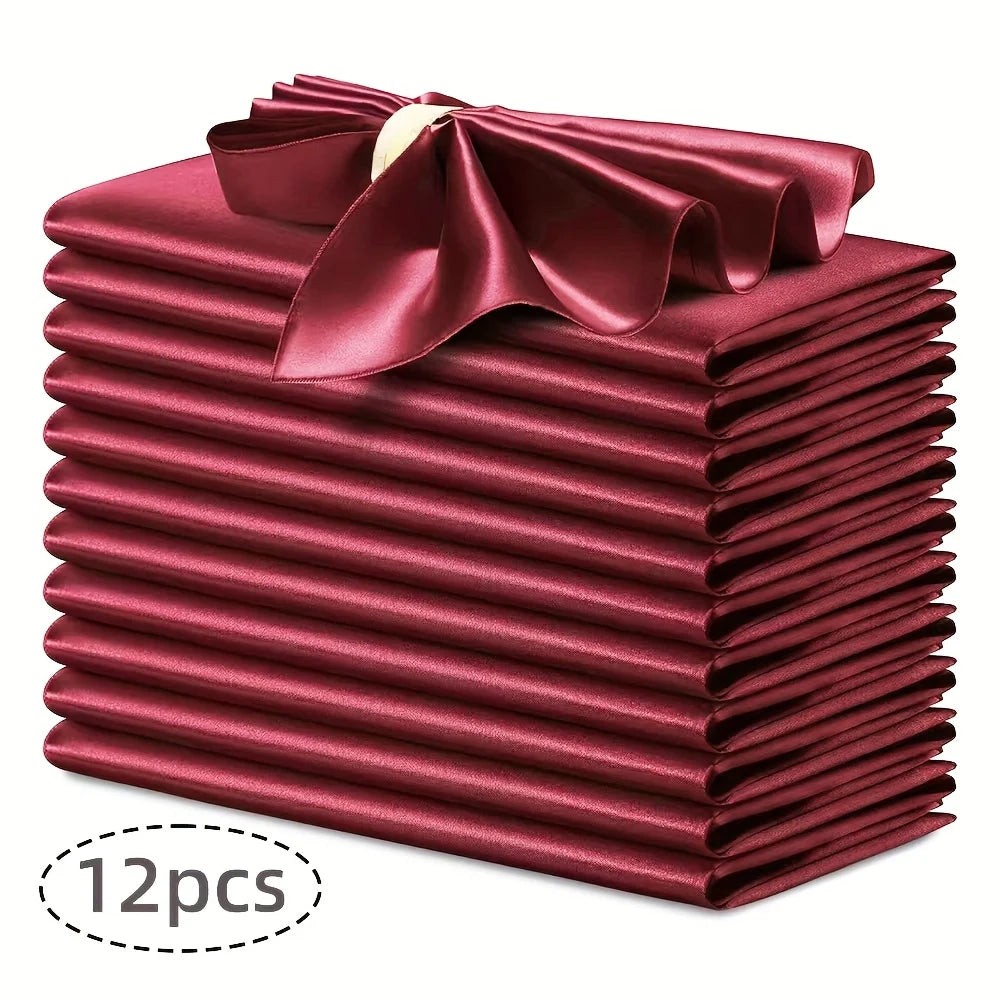 A stack of twelve deep red silky satin dinner napkins with a matching bow on top.