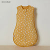 A yellow cotton sleep sack for a baby or toddler, decorated with white leaf patterns.