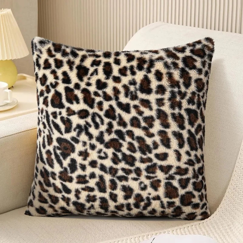 A square leopard print velvet pillow cover resting on a light-colored sofa.