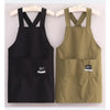 A pair of water-resistant kitchen aprons in black and olive green hanging on a wooden hanger.