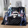A black and colorful Jujutsu Kaisen anime throw blanket draped on a white sofa.