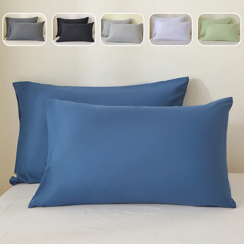 A set of luxury brushed fabric pillowcases in various shades of gray, black, white, and green, displayed against a white back