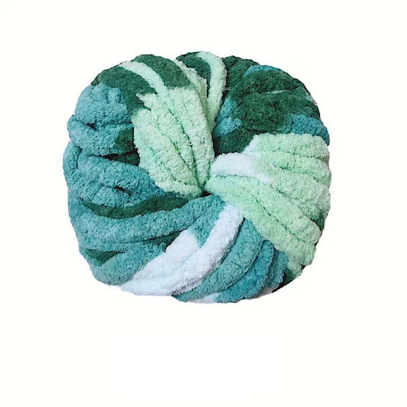 A ball of chunky acrylic yarn in shades of teal and mint green with white accents.