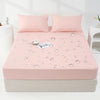 A pink waterproof mattress and bed protector sheet is laid out on a mattress with water droplet designs.