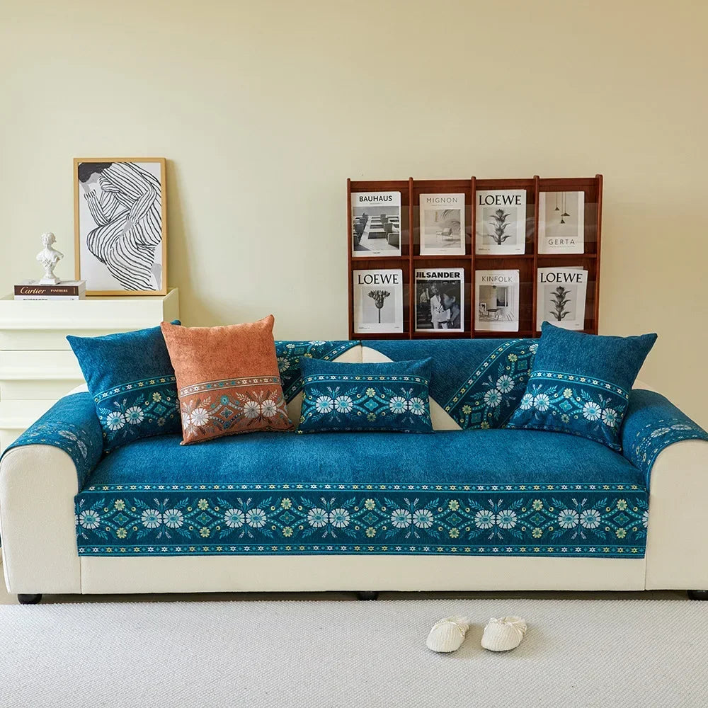 A deep teal chenille sofa cover featuring a patterned fabric and waterproof backing, displayed in a living room setting.