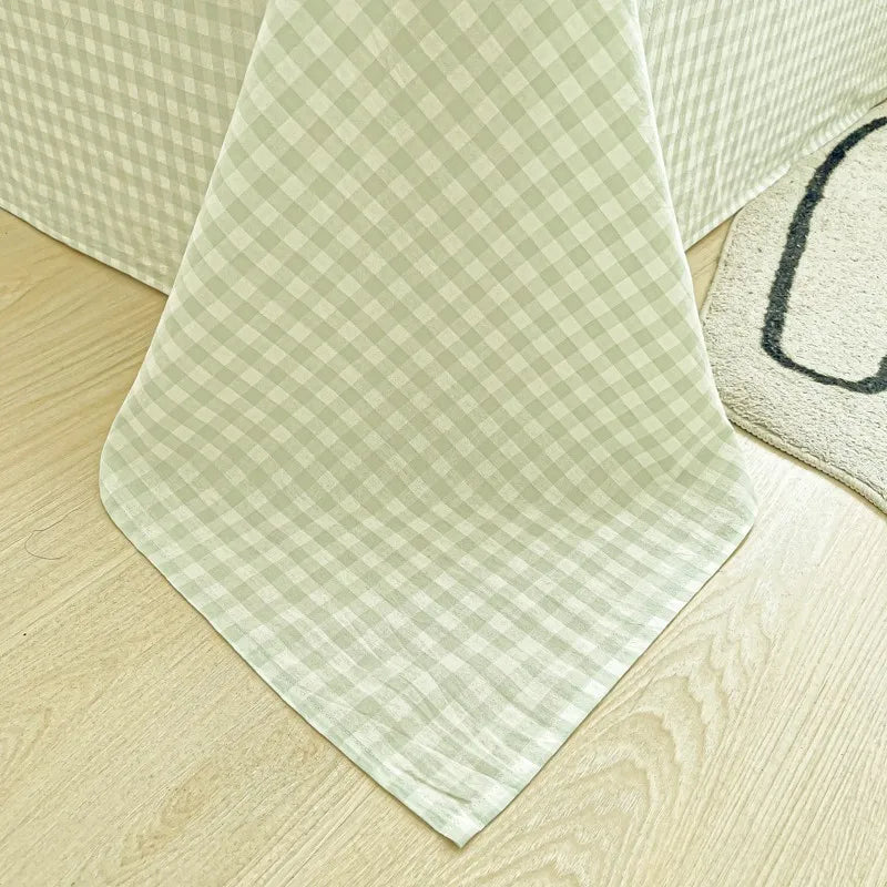 A light green and white checkered fabric napkin or cloth laid on a wooden surface.
