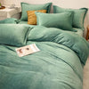 A set of luxurious teal flannel duvet covers and pillows with a textured gold accent pillow.