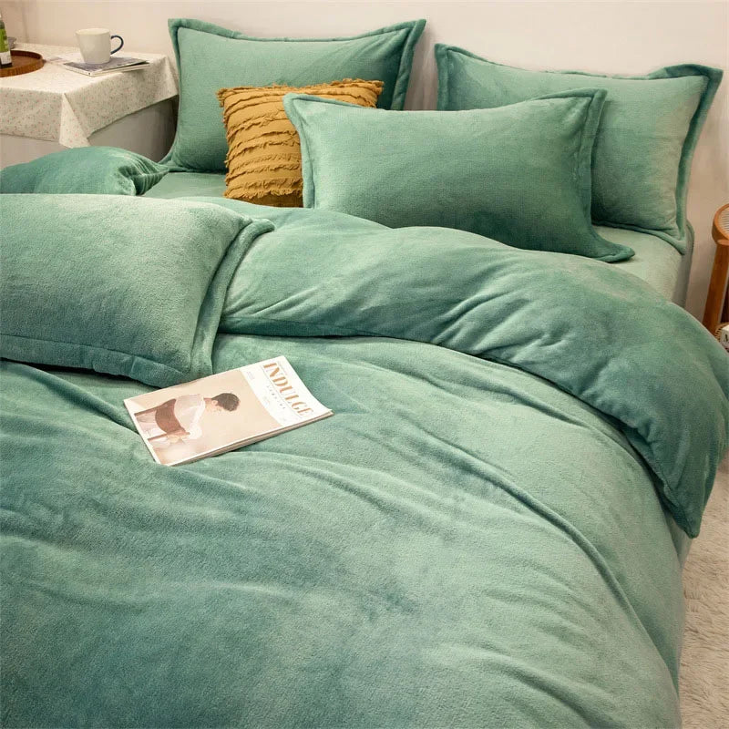 A set of luxurious teal flannel duvet covers and pillows with a textured gold accent pillow.