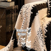 Natural drape fabric in black and cream patterns draped over a dark furniture piece.