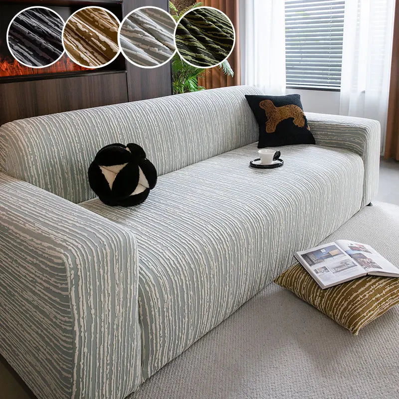 A light gray Jacquard plush elastic sofa cover with striped texture and a dark brown accent pillow on a modern sofa.
