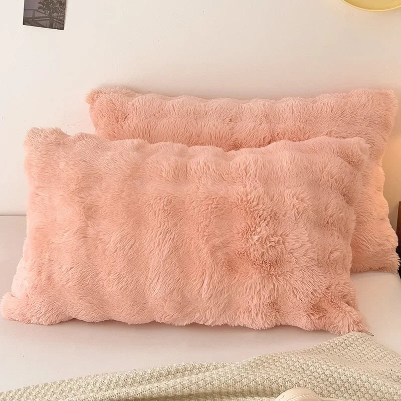 A fluffy, light peach colored decorative pillow cover resting on a white surface.