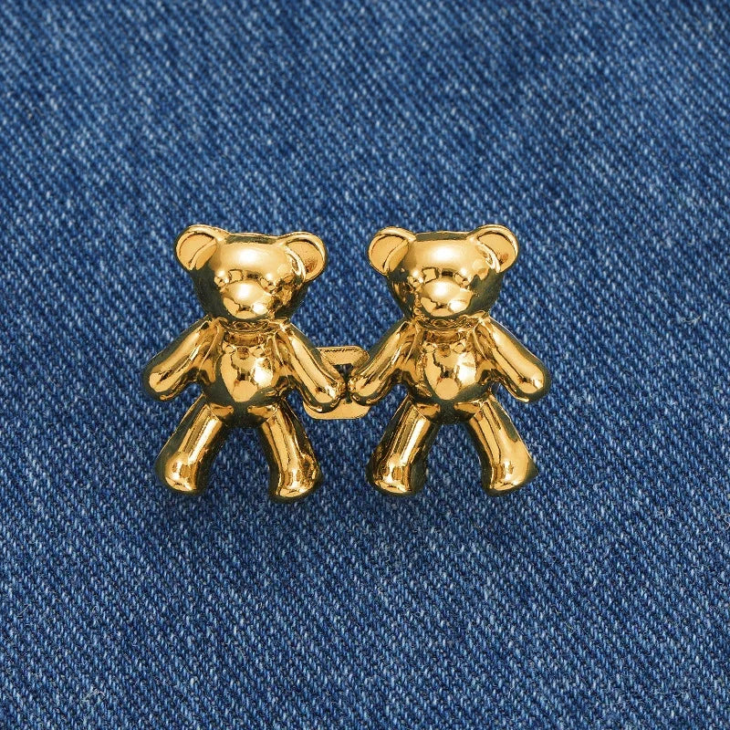 A pair of gold-colored bear button pins designed for jeans.