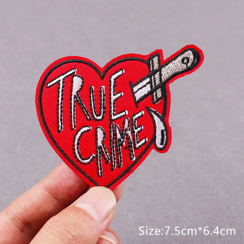 Red heart shaped embroidered patch featuring the text True Crime and a knife
